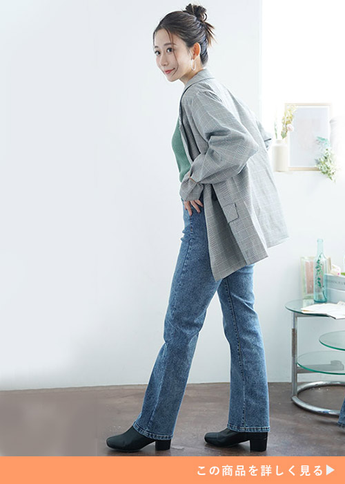 緑のトップス×ストレートデニムパンツにグレーのジャケットを羽織る女性