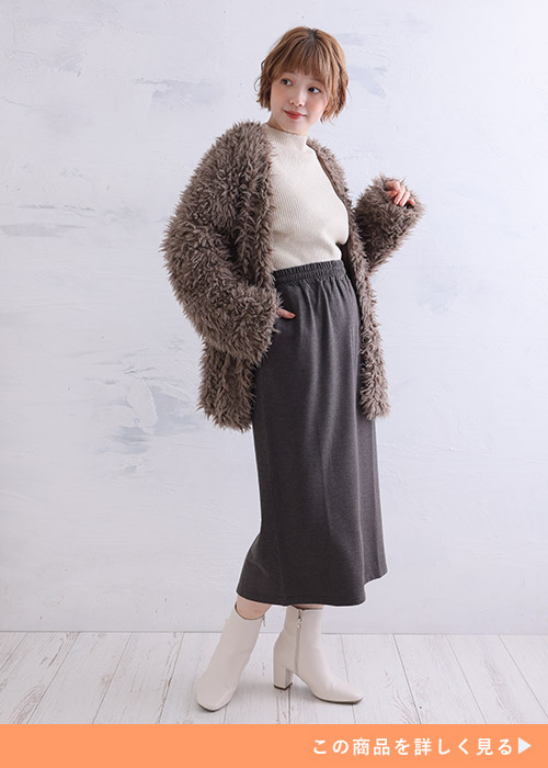 オフホワイトのリブニット×チャコールのタイトスカートに、ブラウンのシャギーニットカーディガンを羽織る女性