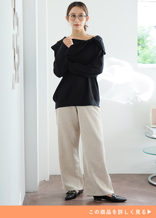 黒のオフショルニット×ベージュのワイドパンツを着る女