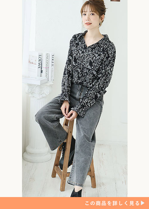 黒のドット柄ブラウス×ブラックデニムを着る女性