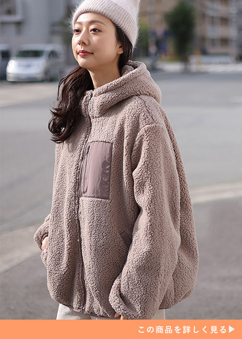 モカブラウンの中綿入りボアフードブルゾンにモヘアニット帽をかぶる女性