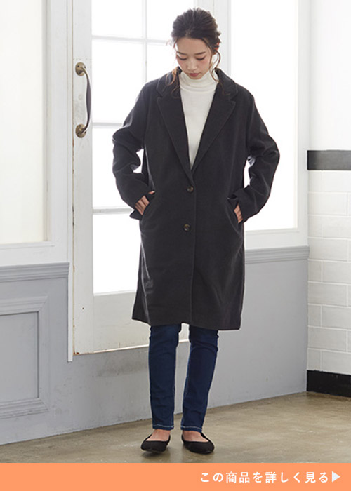 チャコールのフェイクウールチェスターコートにデニムスキニーパンツにフラットシューズを履く女性