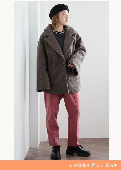 ブラウンのリングウールテーラードコートにローズピンクのテーパードパンツを履く女性