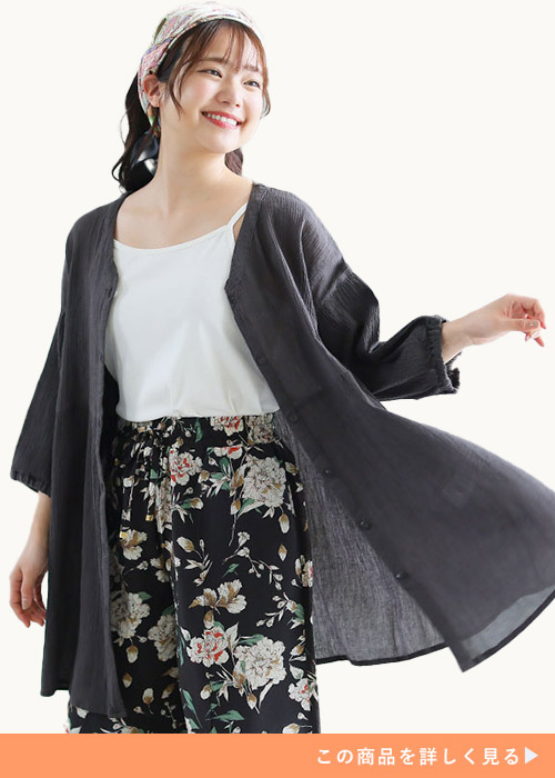白のキャミ×黒の花柄パンツに、チャコールのブラウスを羽織る女性