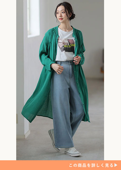 白のプリントT×デニムパンツに、グリーンのロング丈チュニックシャツを羽織る女性