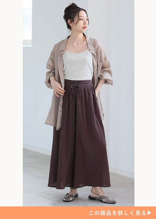 キャミソール×スカンツにシアーシャツを羽織る、ブラウン系ワントーンコーデを着る女性