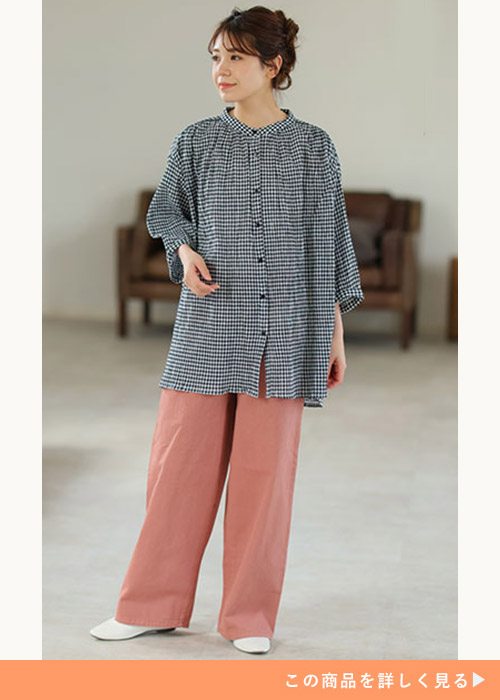 ギンガムチェック柄のシアーシャツ×くすみピンクのパンツを着る女性