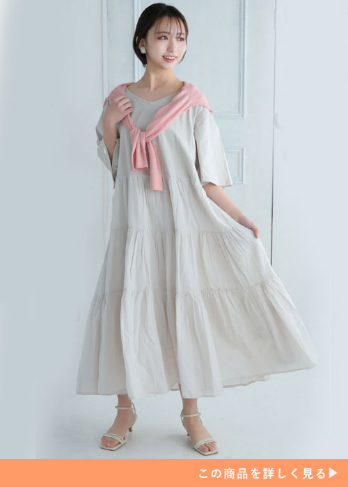 グレージュのティアードワンピを着る女性