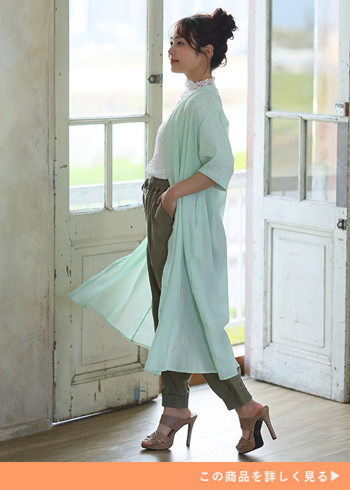 白のレーストップス×カーキパンツに、ミント色のシアーカーディガンを羽織る女性