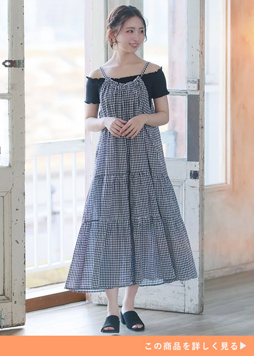 黒のオフショルトップス×ギンガムチェック柄のキャミワンピを着る女性