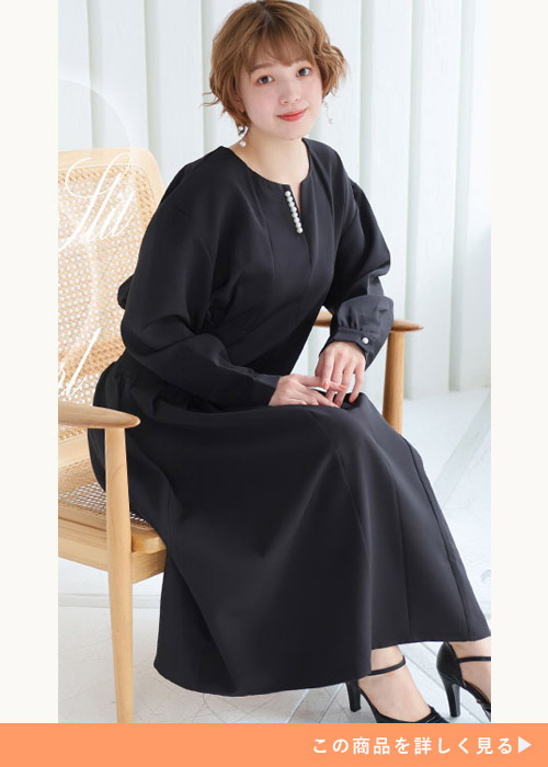 ブラックのパールモチーフワンピースを着てブラックのストラップパンプスを履く女性