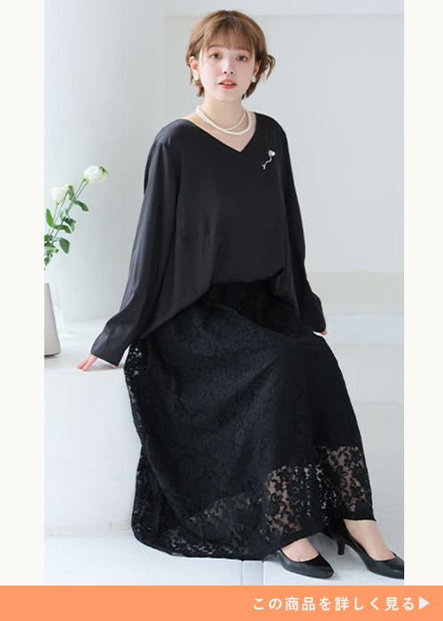 ブラックのドッキングレース ワンピースにブラックのパンプスを履く女性