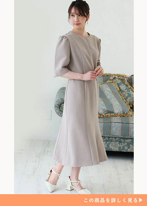 グレージュのワンピースに白のストラップパンプスを履く女性