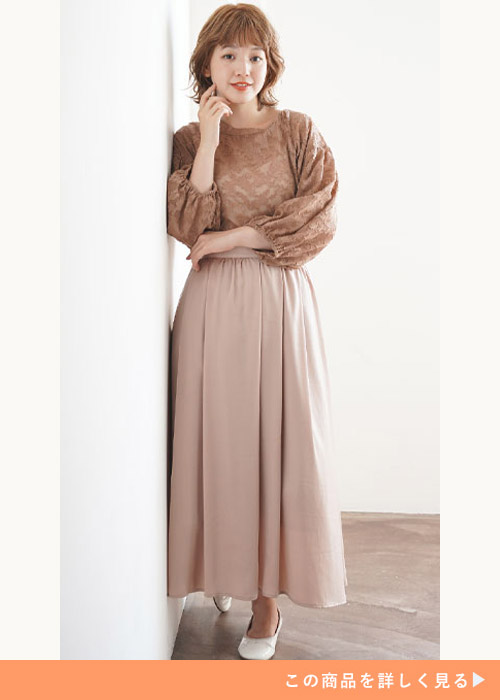 ブラウンの花柄シフォンの前後2WAY ブラウスにハイウエストフレアースカートを履く女性