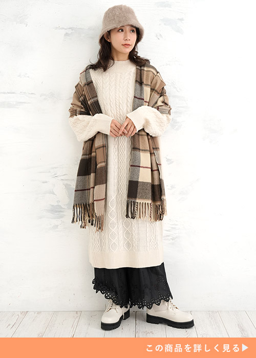 白のニットワンピースの下に黒の裾レースペチパンツを履く女性