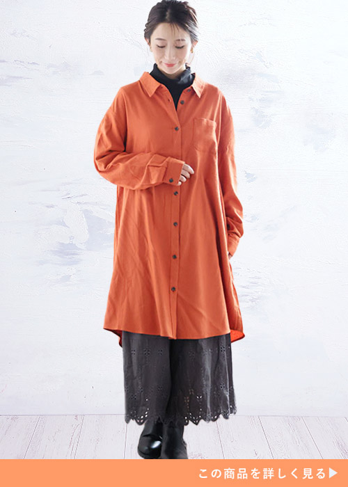 オレンジのシャツワンピのインナーに黒トップス×チャコールのペチパンツを着る女性