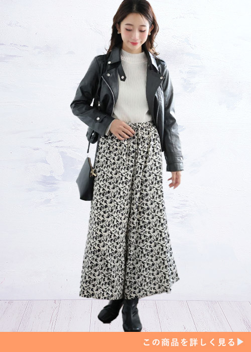 白トップス×モノトーンの花柄スカーチョに、黒のレザージャケットを羽織る女性