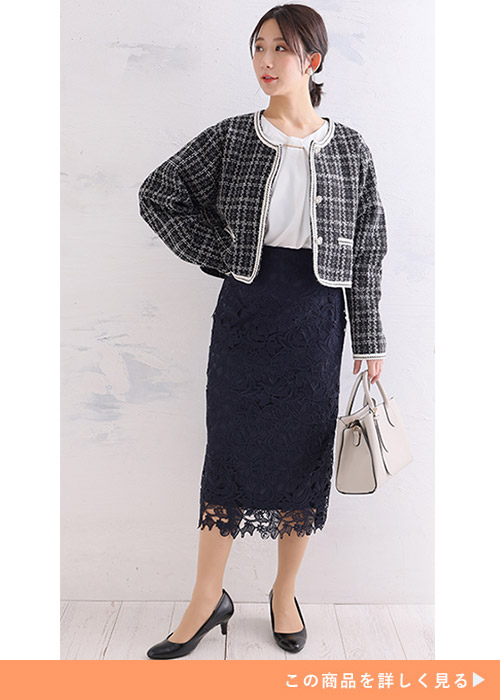 ホワイトのボウタイブラウスにツイードのショートジャケットとレーススカートを履く女性
