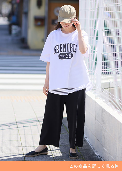 白の「ハッピーさらりん」カレッジプリントTシャツを着る女性