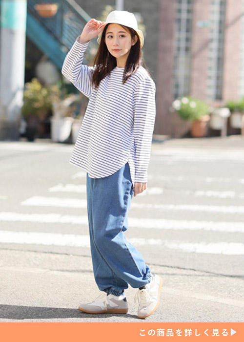 「ハッピーさらりん」のボーダー柄長袖Tシャツ×デニムパンツを着る女性