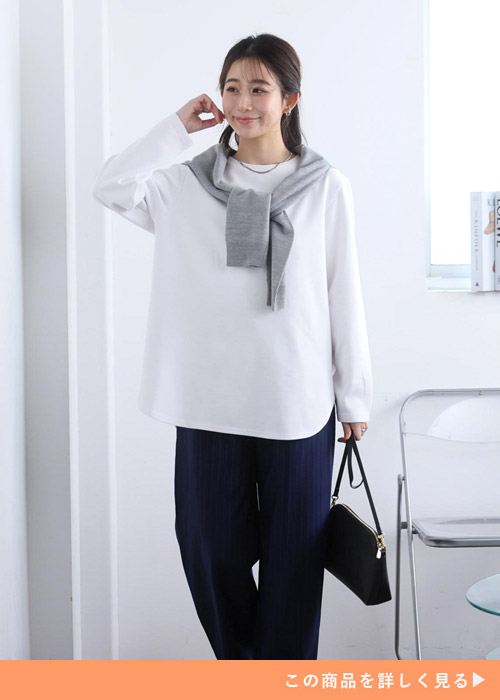 白のロンT×ネイビーのパンツを着て、グレーのトップスを肩に巻く女性