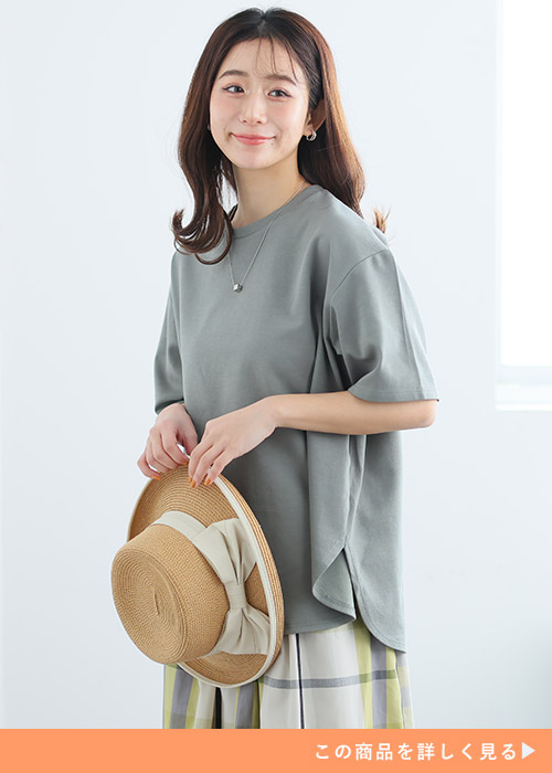 カーキの裾ラウンドTシャツ×イエローのチェック柄スカートを着る女性