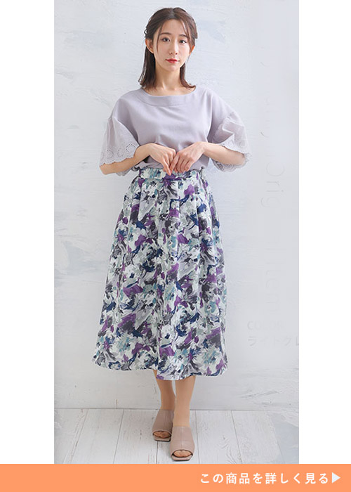 「ハッピーさらりん」のライトグレーの袖レーストップス×花柄スカートを着る女性