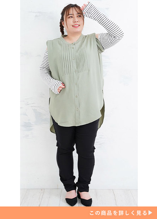 黄緑トップス×黒パンツのコーデに、ボーダー柄のアームカバーを付ける女性