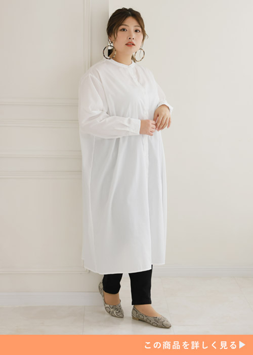 白のシャツワンピース×黒のパンツを着る女性