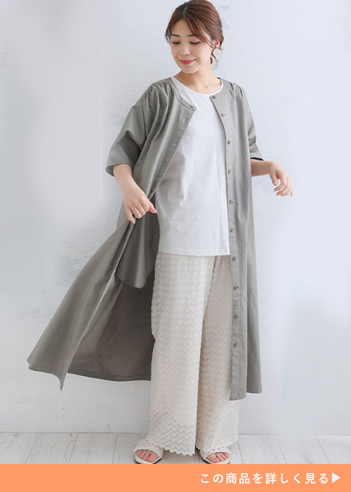 白カットソー×白レースパンツに、ボタンを開けたカーキのシャツワンピースを羽織る女性
