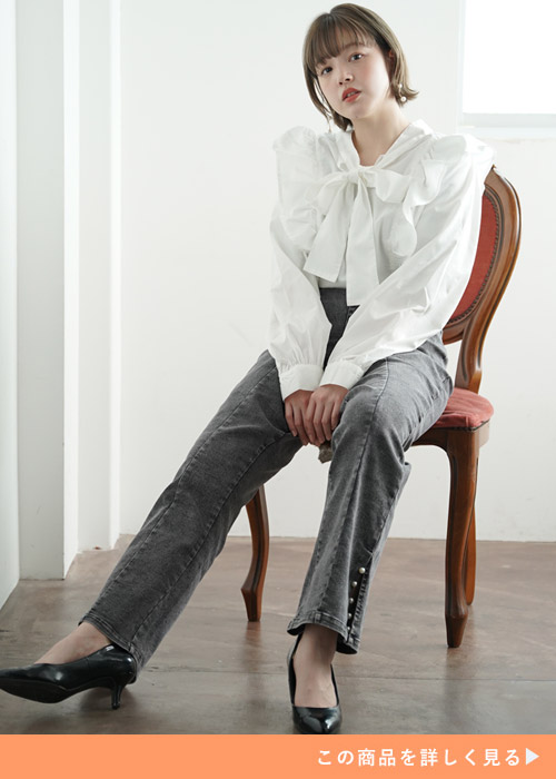 白のリボンタイブラウス×黒のデニムワイドパンツを着る女性