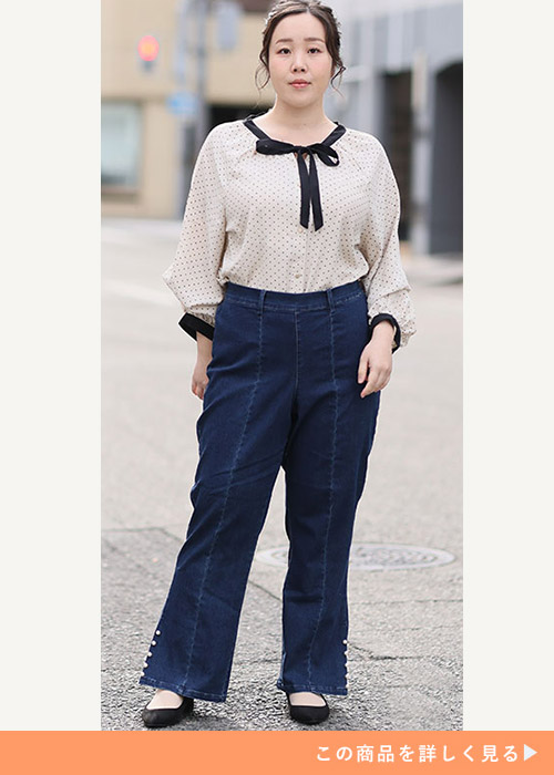ドット柄リボンタイブラウス×センタープレス入りデニムワイドパンツを着る女性