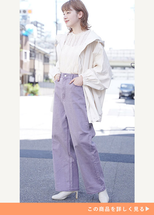 白のレーストップス×紫のカラーデニムワイドパンツに、白のブルゾンを羽織る女性