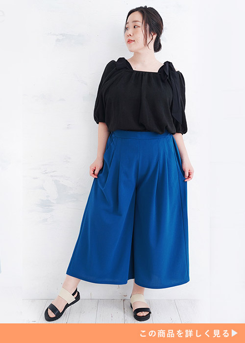 ターコイズブルーのガウチョパンツ履く女性