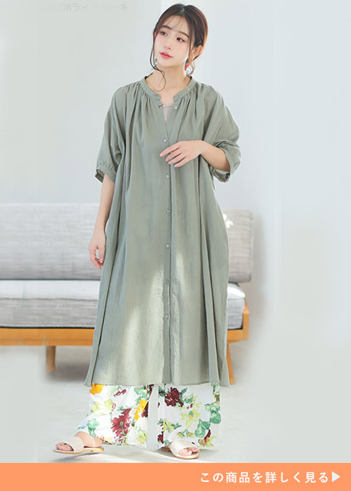 ライトカーキのシャツワンピースと花柄パンツのコーデにサンダルを履く女性