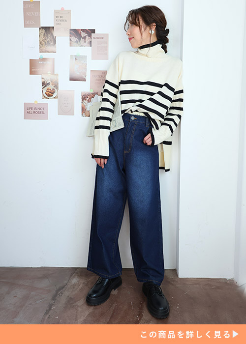 ネイビーのワイドとボーダーニットのコーデにブラックのブーツを履く女性