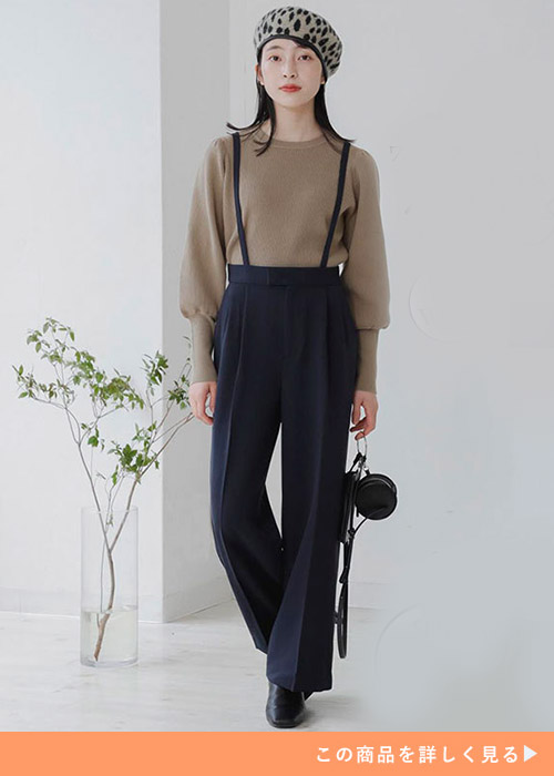 ブラックのワイドストレートパンツとブラウンニットのコーデにブラックブーツを履く女性