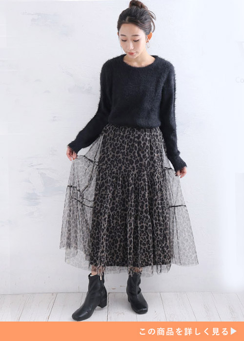 レオパード柄のチュールスカートとブラックニットのコーデにブラックブーツを履く女性