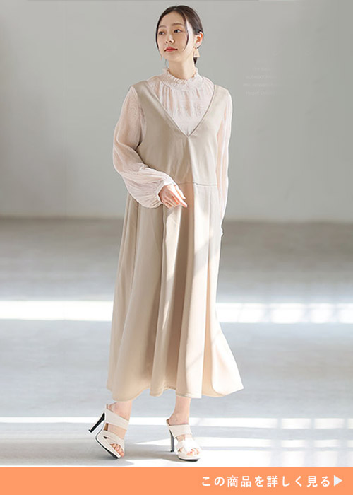 ピンクベージュのシアーブラウス×グレージュのジャンスカを着る女性