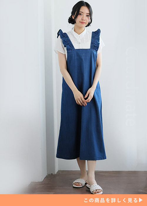 白ブラウス×肩フリルのデニムジャンパースカートを着る女性