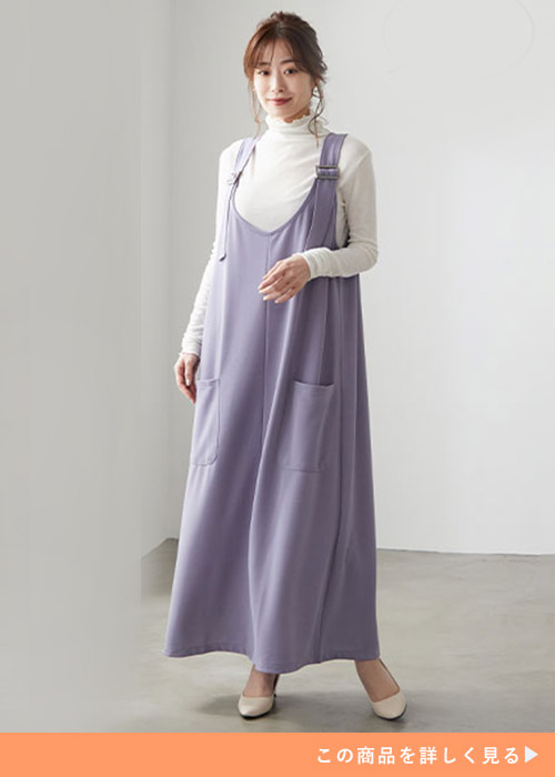 白のシアートップス×ラベンダーブルーのジャンパースカートを着る女性