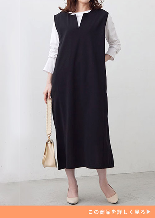 白のロンT×黒のキーネックジャンパースカートを着る女性