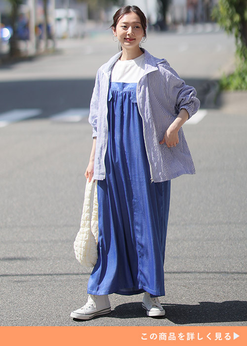 白T×ロング丈のデニムジャンパースカートに、ストライプ柄ブルゾンを着る女性