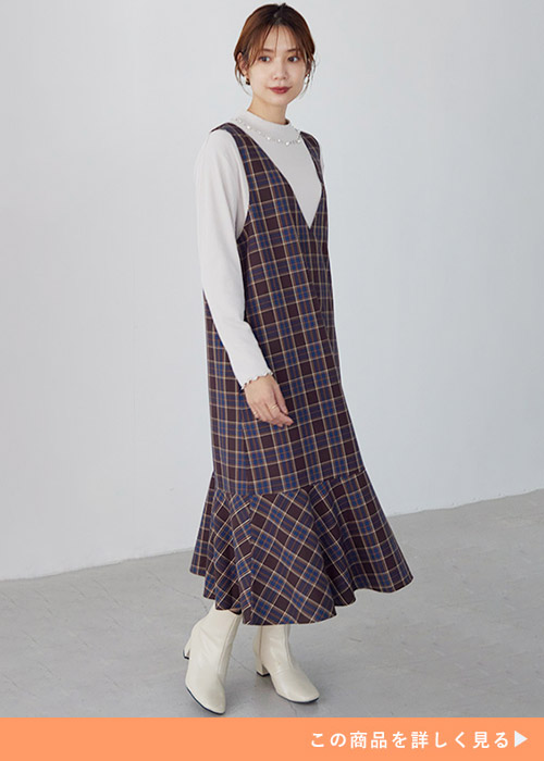 グレージュのリブトップス×ブラウン系のチェック柄ジャンスカを着る女性