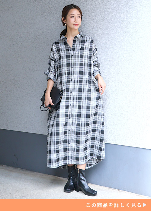 ブラック×オフホワイトのチェックシャツワンピースにブラックのブーツを履く女性