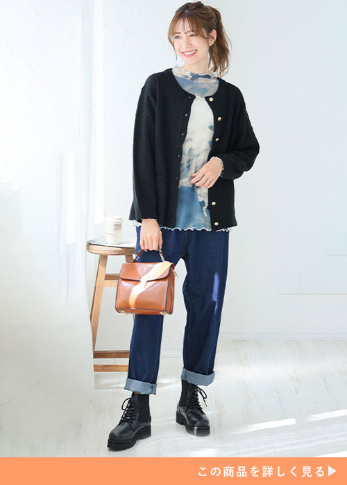 デニムコーデに金ボタンのカーディガンを着る女性