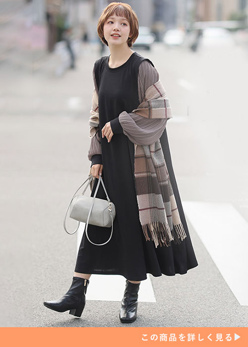 ブラック×モカのワンピースにブラウン系チェックのストールを羽織る女性