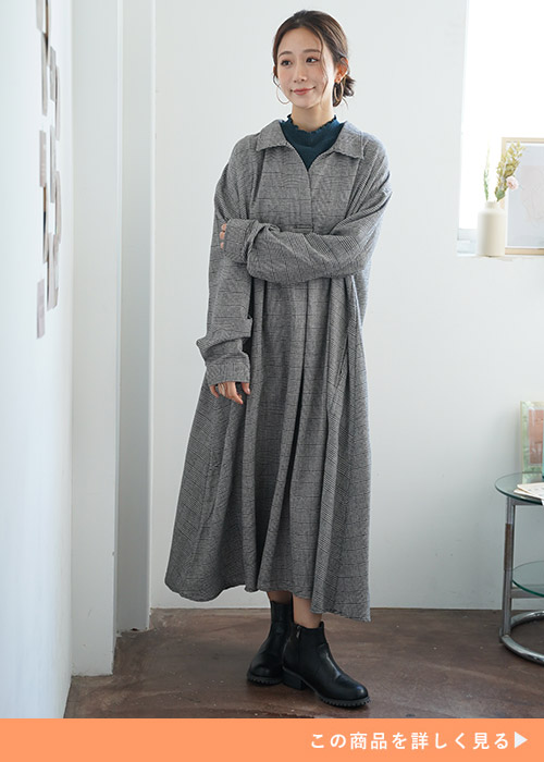 グレンチェックのフランネルワンピースにダークグリーンのトップスをレイヤ―ドする女性