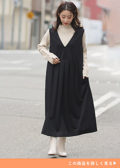 ベージュのトップスとブラックのジャンスカのコーデにホワイトブーツを履く女性