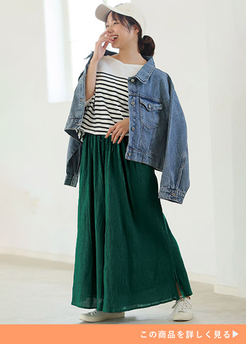 ボーダーTシャツ×緑のフレアスカンツにGジャンを肩掛けする女性